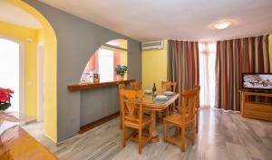 a dining room with a table and chairs and a television at Ona Campanario in La Cala de Mijas