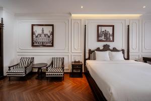 a bedroom with a bed and two chairs and a table at FELIZ Executive Stay - Central Thủ Dầu Một in Ga Phú Văn +42 photos