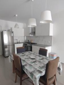 eine Küche mit einem Tisch mit Stühlen und einem Kühlschrank in der Unterkunft Caesar Resort & Spa - 1 Bed luxury apartment in Trikomo