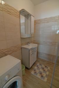 a bathroom with a sink and a washing machine at Apartment Nevena in Mali Lošinj