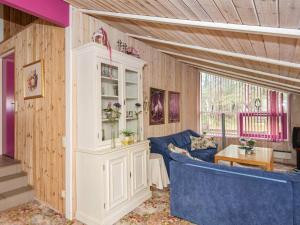 a living room with a blue couch and a white cabinet at 8 person holiday home in Glesborg in Fjellerup