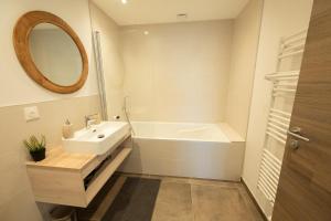 a bathroom with a sink and a tub and a mirror at Le 214, Entre Lacs et Montagnes in Les Rousses +20 photos