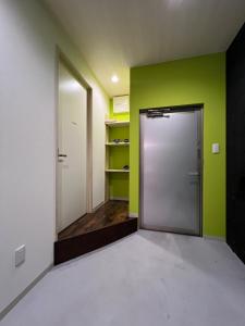 an empty room with a door and a green wall at uchimachi201 しげの里リノベーション52平方メートルJR高松駅14分ことでん片原町駅3分土足OK in Takamatsu