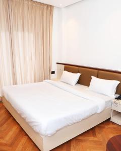 a bedroom with a large bed with white sheets at Shree Jayati Inn in Ayodhya