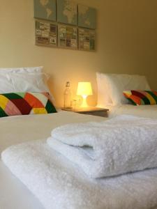 a white towel laying on a bed with a lamp at Vicarage Lodge Birmingham in Birmingham