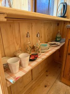 メスティアにあるWooden Houseの2つのボトルとボウルが置かれた木製の棚 +9枚の写真
