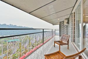 Un balcón con una silla y vistas al océano. en Hotel Pine Mountain View-Cheap Hotels Best Prices Guaranteed with Deals-Free Parking-cricket stadium 5 km, en Dharamshala