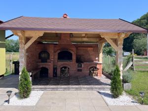a large wooden pavilion with a brick building at Pensiunea Mihade in Vama Buzăului