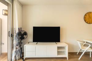 a living room with a tv on a white cabinet at Panarea Chaparal in Costa Del Silencio