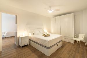 a white bedroom with a bed and two candles on it at Panarea Chaparal in Costa Del Silencio +13 photos