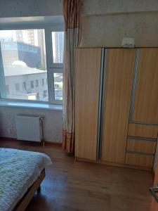 a bedroom with a wooden cabinet and a window at Apartment in Ulaanbaatar, Next to Narantuul Market, ,Mongolia in Ulaanbaatar