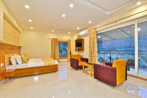 ein Schlafzimmer mit Bett und ein Wohnzimmer in der Unterkunft Marina Group of hotels Pine View Sudher- Best Prices Guaranteed with Deals- Free Parking-cricket stadium 5 km-Mountain View in Dharamshala
