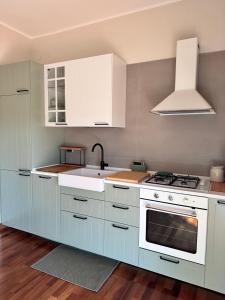 a kitchen with white cabinets and a sink at La casetta bellevue suite in Torre del Greco