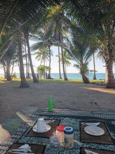 a table with plates of food on the beach at Nenas Homestay in Soso +16 photos