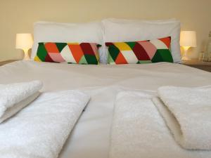 Una cama blanca con mantas blancas y almohadas. en Vicarage Lodge Birmingham en Birmingham