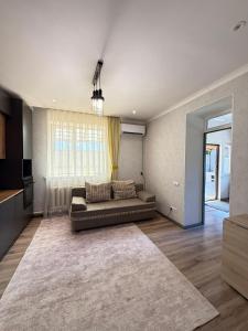 a living room with a couch and a large rug at Apart 23 in Karakol