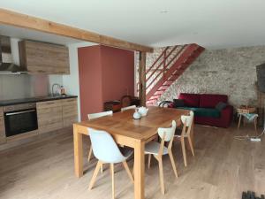 a kitchen and dining room with a wooden table and chairs at Jolie dépendance proche forêt- Nemours in Poligny