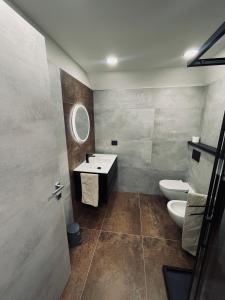 a bathroom with a sink and a toilet and a mirror at Legend Loft in Pont-Saint-Martin +37 photos