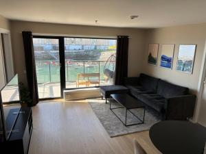 a living room with a couch and a large window at New Aptartment Ocean View Central in Tromsø
