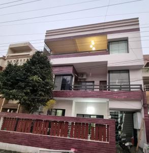 an apartment building with a balcony and a tree at Satyabhama Homestay - Tulip - Two BHK luxury apartment in Indore