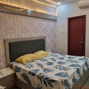 a bed in a room with a red door at Satyabhama Homestay - Tulip - Two BHK luxury apartment in Indore