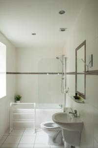 a white bathroom with a toilet and a sink at The Coach House in Otterburn