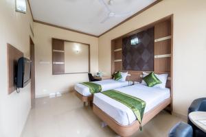 a hotel room with two beds and a tv at Treebo ESS Grande in Coimbatore