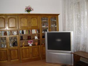 a living room with a television and a wooden cabinet at Somogyi Vendégház in Zamárdi