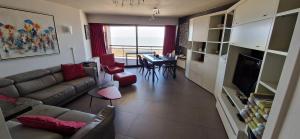 a living room with a couch and a table at Bristol Palace Seaview 7e verdieping, 30 meter van strand in Blankenberge