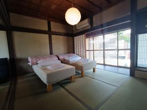 Postel nebo postele na pokoji v ubytování dannouraしげの里 1棟貸切 築120年古民家 バーベキュー 海が見える駐車場無料 + 81 fotografií