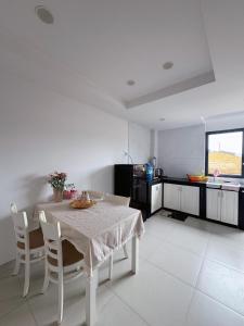 una cucina bianca con tavolo e sedie bianchi di MIA's homestay a Phu Quoc