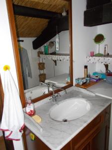 La salle de bains est pourvue d'un lavabo blanc et d'un miroir. dans l'établissement Le journal Blanc, à Notre-Dame-de-Monts