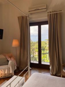 a bedroom with a bed and a large window at “Casa Amélie” in Grottaferrata