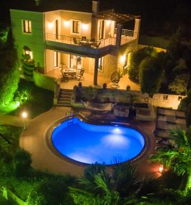 una piscina frente a una casa por la noche en Villa Gianna, en Almyrida