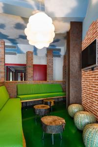 un bar verde con bancos, mesas y TV en Blanco Albergue en Santiago de Compostela