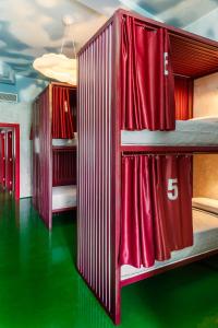 1 dormitorio con 2 literas y cortinas rojas en Blanco Albergue, en Santiago de Compostela