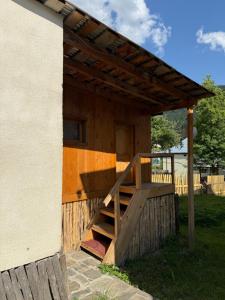 メスティアにあるWooden Houseの木製の階段と木製のパーゴラのある家