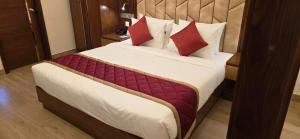 a bedroom with a large bed with red pillows at Hotel Pentagon in Ettumānūr