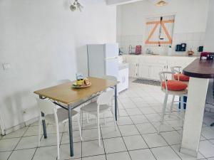 a kitchen with a wooden table and chairs in a kitchen at Kaz a Béa - T3 climatisé avec citerne tampon - gare maritime in Saint-François