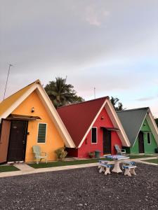 Family Cottage Beseri في كانجار: مجموعة من المنازل الملونة مع مقعد في المقدمة