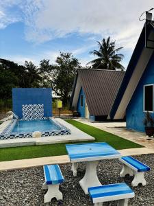 Family Cottage Beseri في كانجار: منزل به حوض سباحة ومقاعد زرقاء وبيضاء