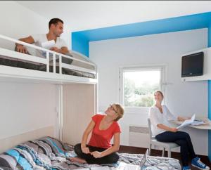 Un par de mujeres sentadas en una cama en un dormitorio en hotelF1 Epinay sur Orge, en Épinay-sur-Orge