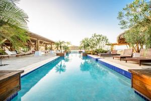 una piscina en un complejo con sillas y árboles en Villa Del Mar - Blue Venao 3BR, en Playa Venao