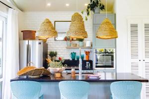 Una cocina con un mostrador con sillas y luces azules. en Villa Del Mar - Blue Venao 3BR, en Playa Venao