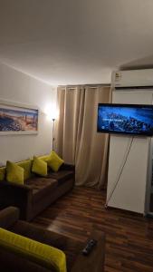 Una sala de estar con un sofá y un televisor de pantalla plana. en Mini Apartamento con Aire acondicionado, en Tumbes