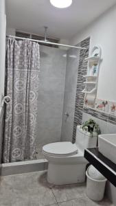 Un baño con inodoro, ducha y lavabo. en Mini Apartamento con Aire acondicionado, en Tumbes