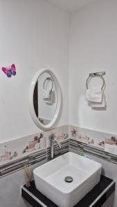 Un baño con un lavabo blanco y un espejo. en Mini Apartamento con Aire acondicionado, en Tumbes