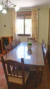 Un comedor con mesa y sillas de madera. en Casa Montaña, en Arriate