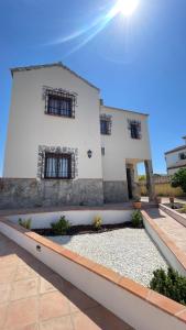 Una casa blanca con ventanas en un lateral. en Casa Montaña, en Arriate