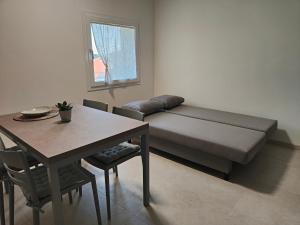 a living room with a couch and a table and a table and chairs at Soggiorno in villa - apt with kitchen and terrace in Gambellara